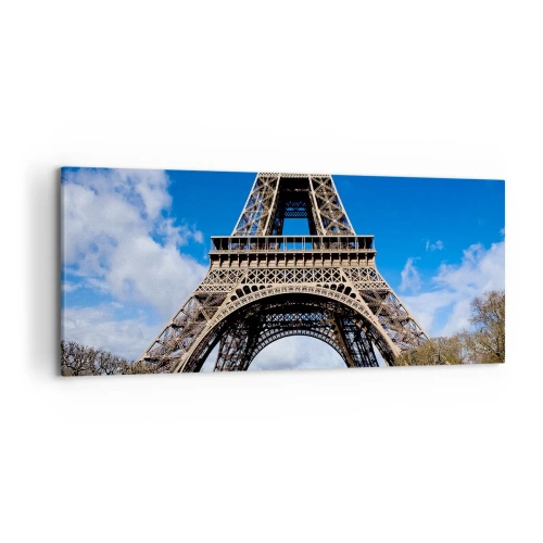 Obraz na płótnie - Wieża Eiffla na tle niebieskiego nieba i zielonego parku - 120x50cm - Cały Paryż u jej stóp - Nowoczesna dekoracja ścienna do salonu i sypialni ARTTOR