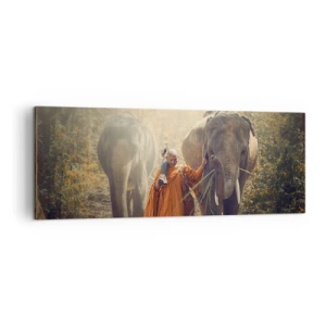 Obraz na płótnie - Mnich w pomarańczowej szacie prowadzący słonia w lesie - 140x50cm - Pełne zrozumienie - Nowoczesna dekoracja ścienna do salonu i sypialni ARTTOR