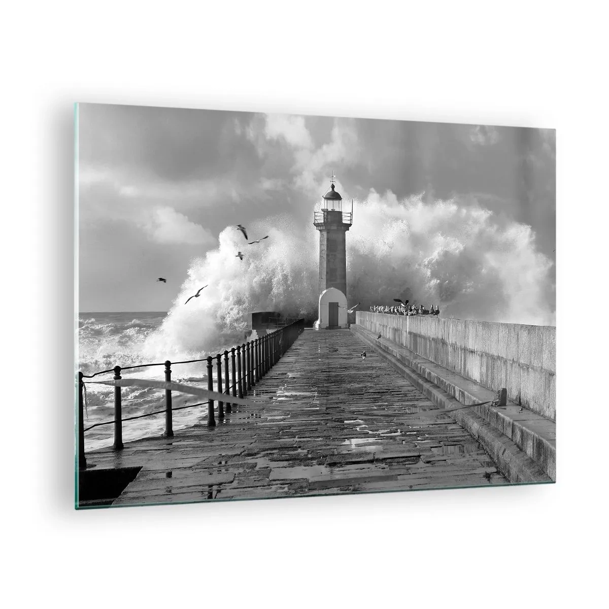 Obraz na szkle - Czarno-białe zdjęcie latarni morskiej wśród rozbijających się fal - 70x50cm - Nieustraszona - Nowoczesna dekoracja ścienna do salonu i sypialni ARTTOR