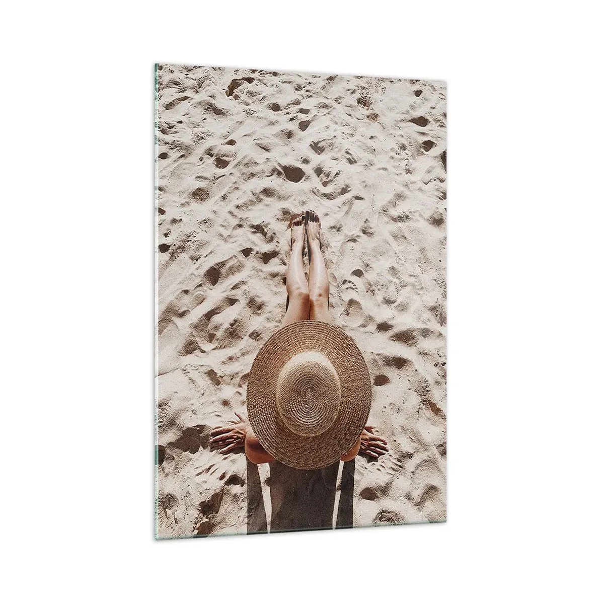 Obraz na szkle - Kobieta w słomkowym kapeluszu leżąca na piasku - 70x100cm - Wymarzony czas - Nowoczesna dekoracja ścienna do salonu i sypialni ARTTOR