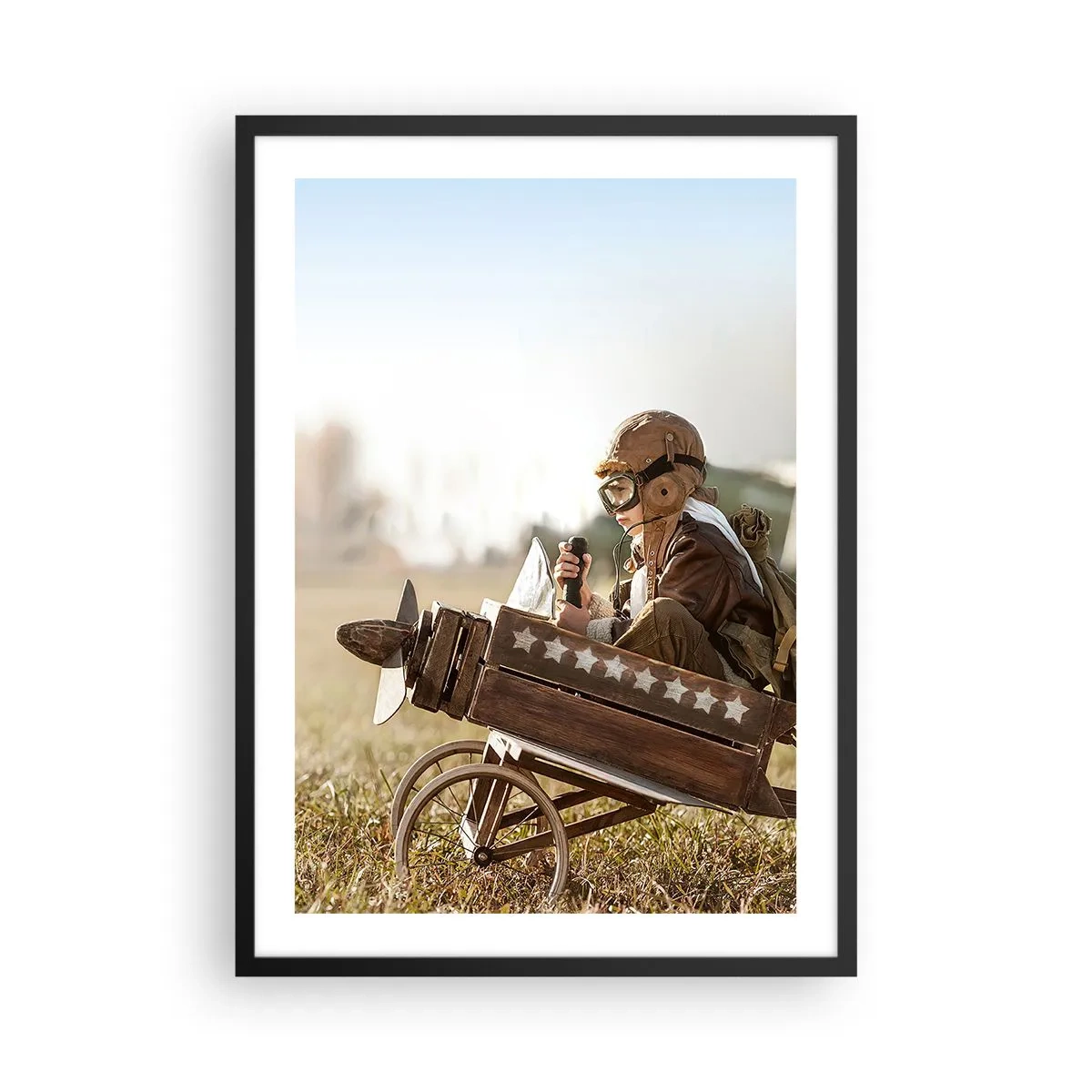 Plakat w czarnej ramie - Dziecko w drewnianym samolocie z gwiazdami na tle pola - 50x70cm - Start ku marzeniu - Nowoczesna dekoracja ścienna do salonu i sypialni ARTTOR
