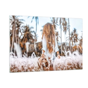 Obraz na szkle - Kobieta wśród traw z kapeluszem w ręku na tle palm - 120x80cm - Zrodzona z puchu traw - Nowoczesna dekoracja ścienna do salonu, kuchni i sypialni ARTTOR