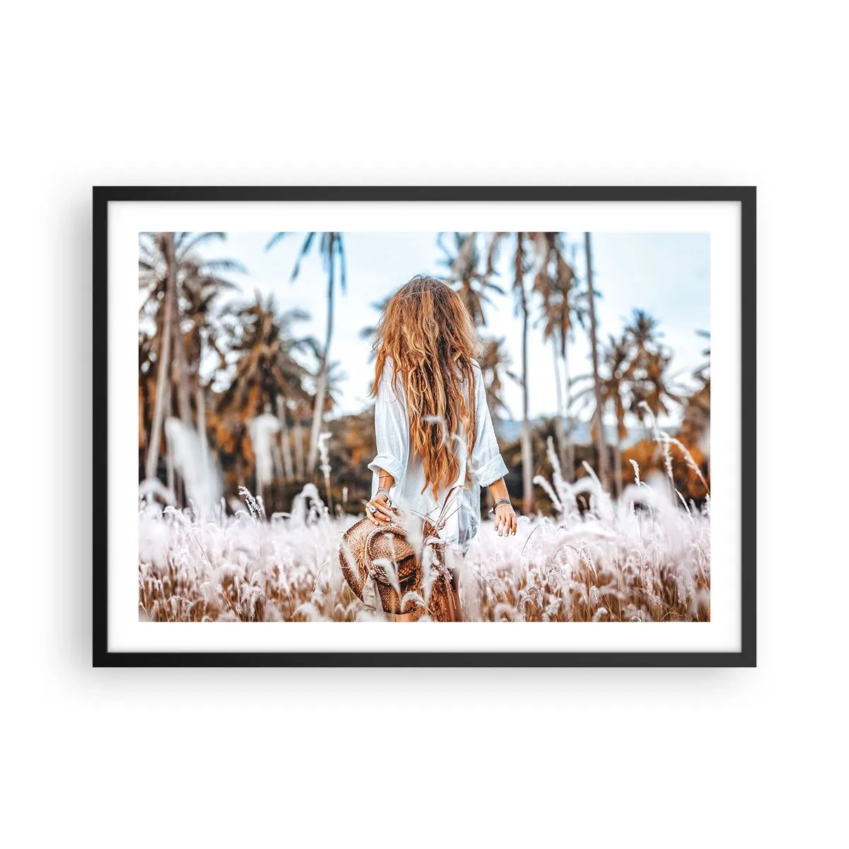 Plakat w czarnej ramie - Kobieta w polu traw z palmami w tle o zachodzie słońca - 70x50cm - Zrodzona z puchu traw - Nowoczesna dekoracja ścienna do salonu i sypialni ARTTOR