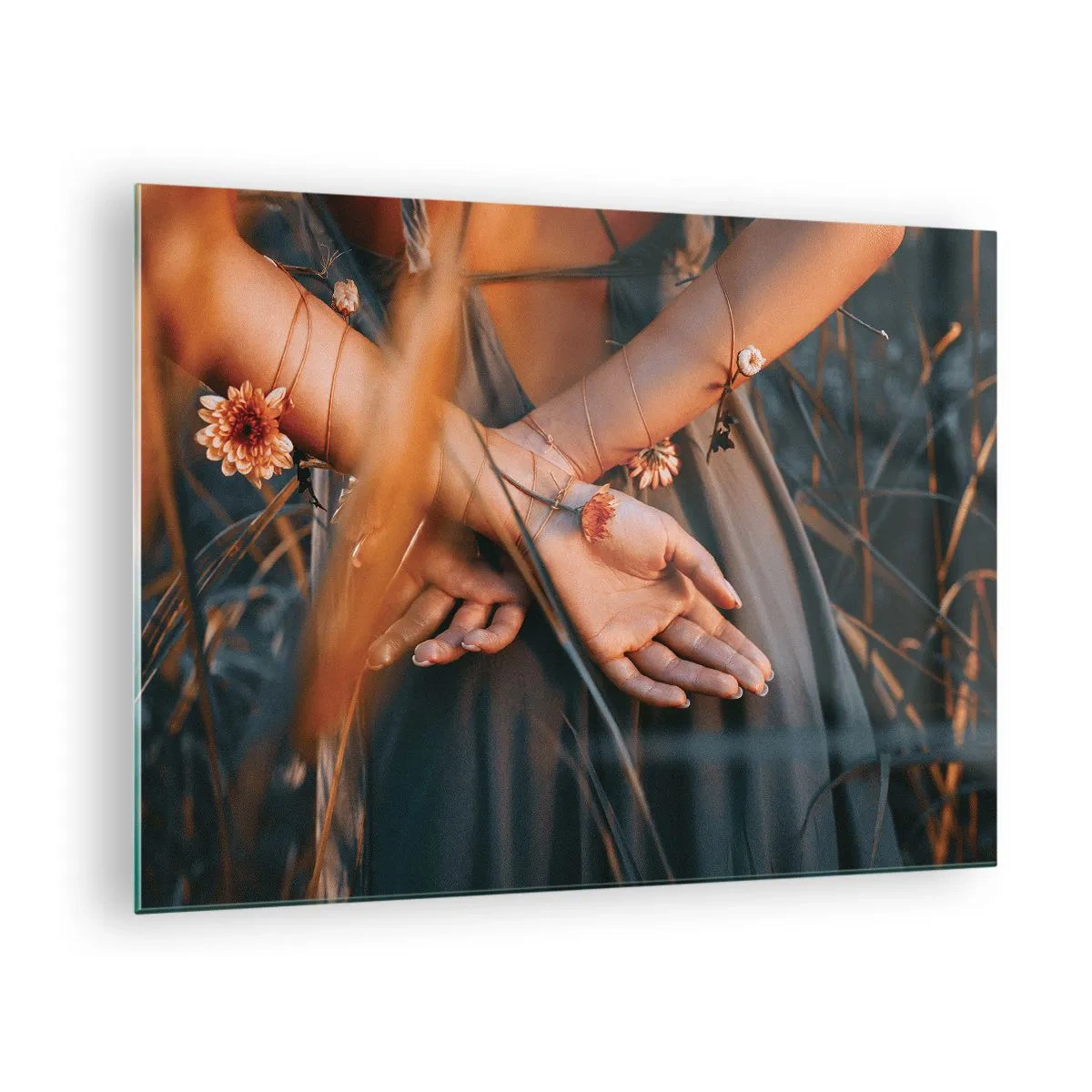 Obraz na szkle - Zbliżenie splecionych dłoni kobiety z kwiatami na tle traw - 70x50cm - Związana z naturą - Nowoczesna dekoracja ścienna do salonu i sypialni ARTTOR