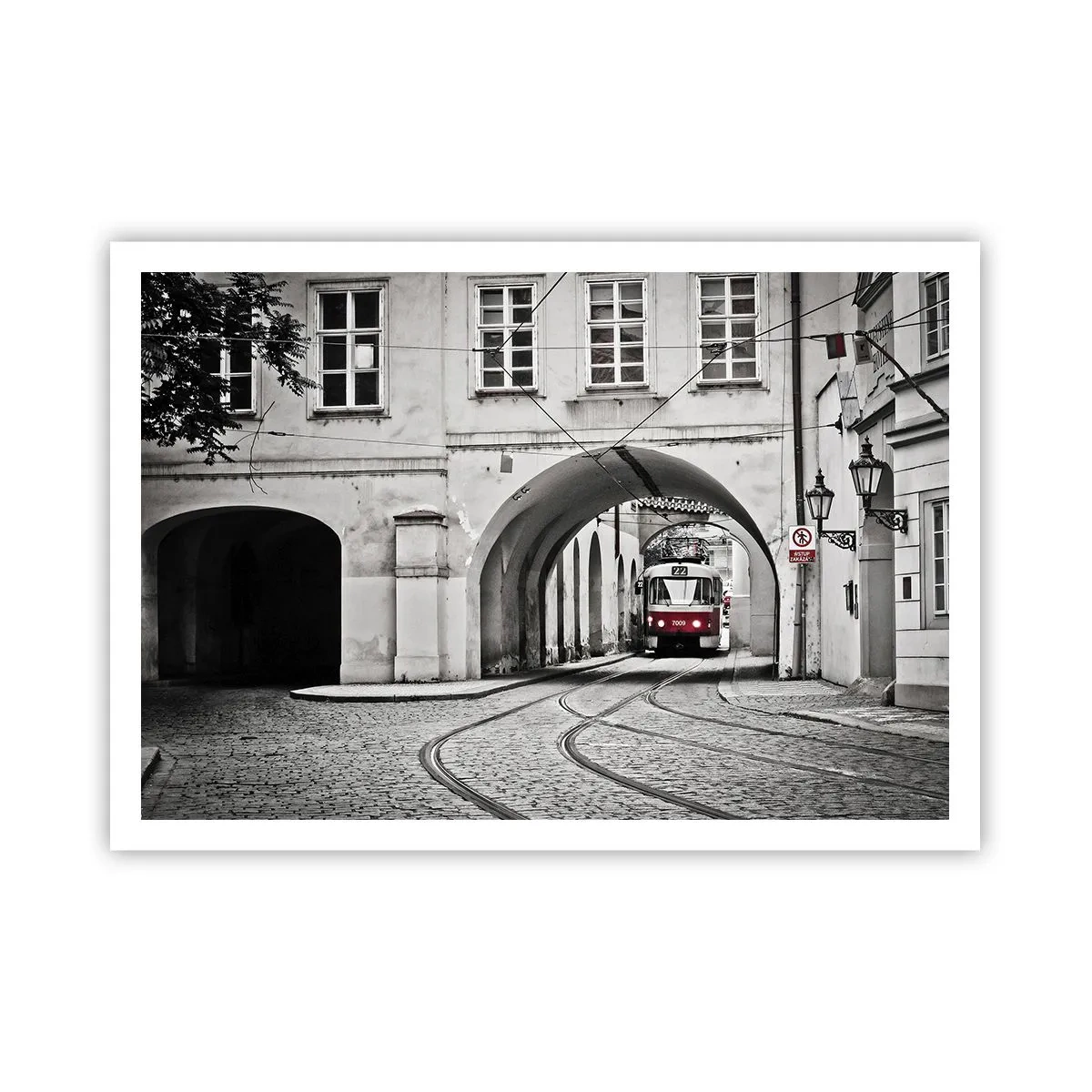 Plakat - Czarno-biały tramwaj w zabytkowej uliczce miasta - 100x70cm - Przez miejski labirynt - Nowoczesna dekoracja ścienna do salonu i sypialni ARTTOR