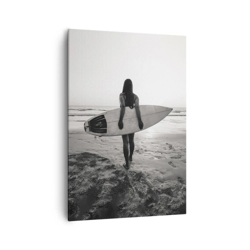 Obraz na płótnie - Kobieta z deską surfingową na plaży w czerni i bieli - 70x100cm - Córka morskiej fali - Nowoczesna dekoracja ścienna do salonu i sypialni ARTTOR