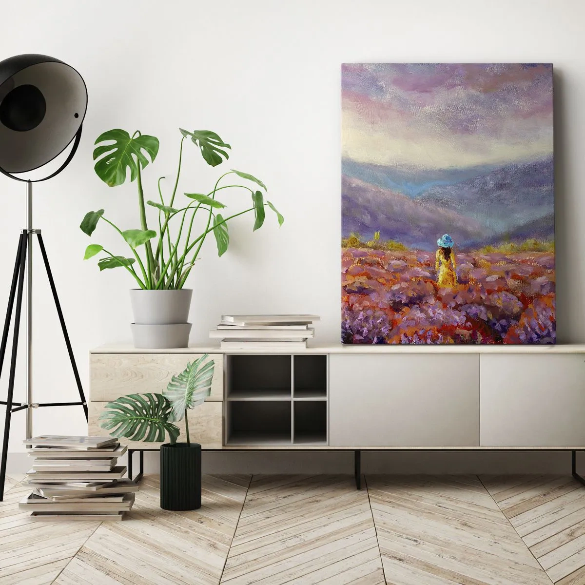 Obraz na płótnie - Kobieta w kapeluszu spacerująca po polu lawendy na tle gór - 50x70cm - W lawendowym świecie - Nowoczesna dekoracja ścienna do salonu, kuchni i sypialni ARTTOR