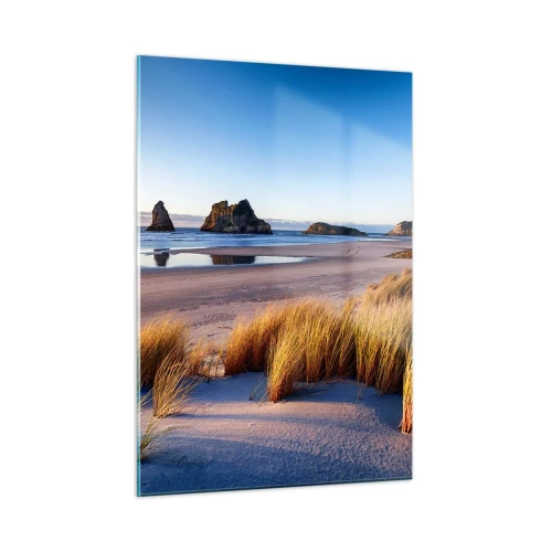Obraz na szkle - Plaża o świcie z trawami i skałami w tle przy spokojnym morzu - 50x70cm - Dla poszukiwaczy spokoju - Nowoczesna dekoracja ścienna do salonu, kuchni i sypialni ARTTOR