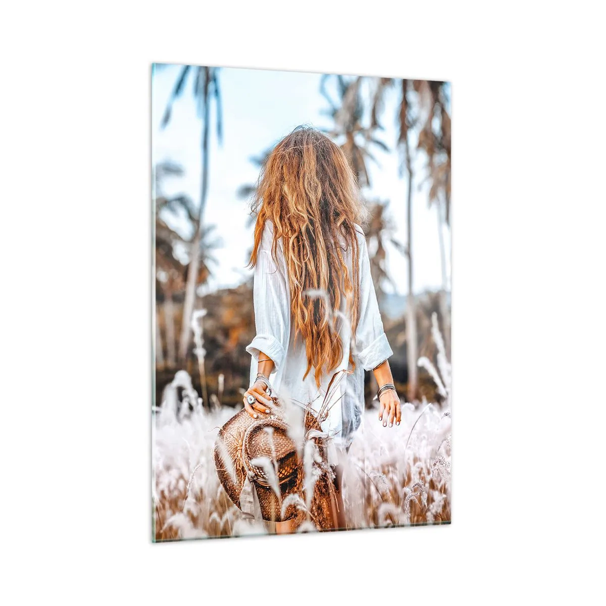 Obraz na szkle - Kobieta wśród traw z kapeluszem w ręku na tle palm - 50x70cm - Zrodzona z puchu traw - Nowoczesna dekoracja ścienna do salonu, kuchni i sypialni ARTTOR