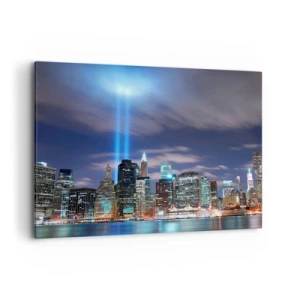 Obraz na płótnie - Nocna panorama miasta z dwoma jasnymi snopami światła na niebie - 100x70cm - Światłem dosięgnąć nieba - Nowoczesna dekoracja ścienna do salonu, kuchni i sypialni ARTTOR