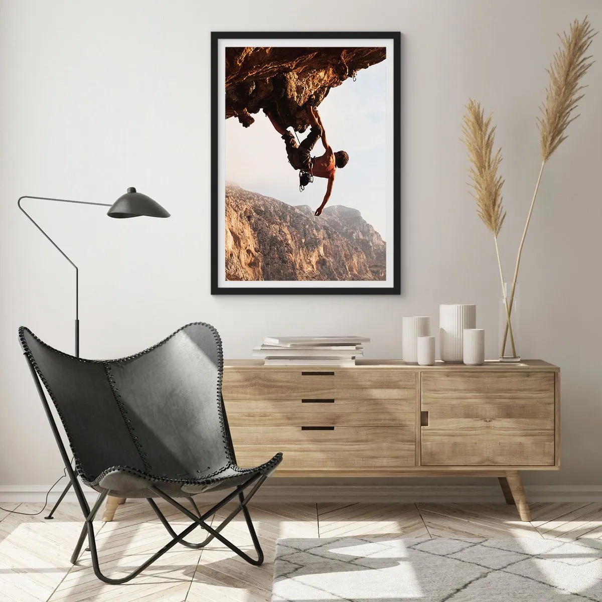 Plakat w czarnej ramie - Wspinaczka na skałach w promieniach słońca - 50x70cm - Świat skurczony w garści na obrywie głazu - Nowoczesna dekoracja ścienna do salonu i sypialni ARTTOR