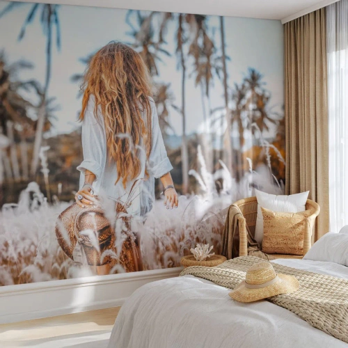 Fototapeta Premium Sand - Kobieta wśród traw na tle palmowego krajobrazu - 100x70cm - Zrodzona z puchu traw - Nowoczesna dekoracja ścienna do salonu, kuchni i sypialni ARTTOR