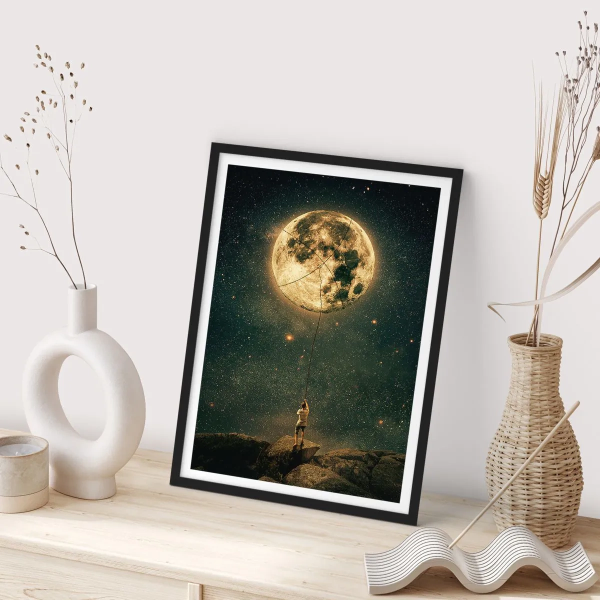 Plakat w czarnej ramie - Postać trzymająca Księżyc na linie w gwiezdnym krajobrazie - 50x70cm - Jeden taki, co ukradł Księżyc - Nowoczesna dekoracja ścienna do salonu i sypialni ARTTOR