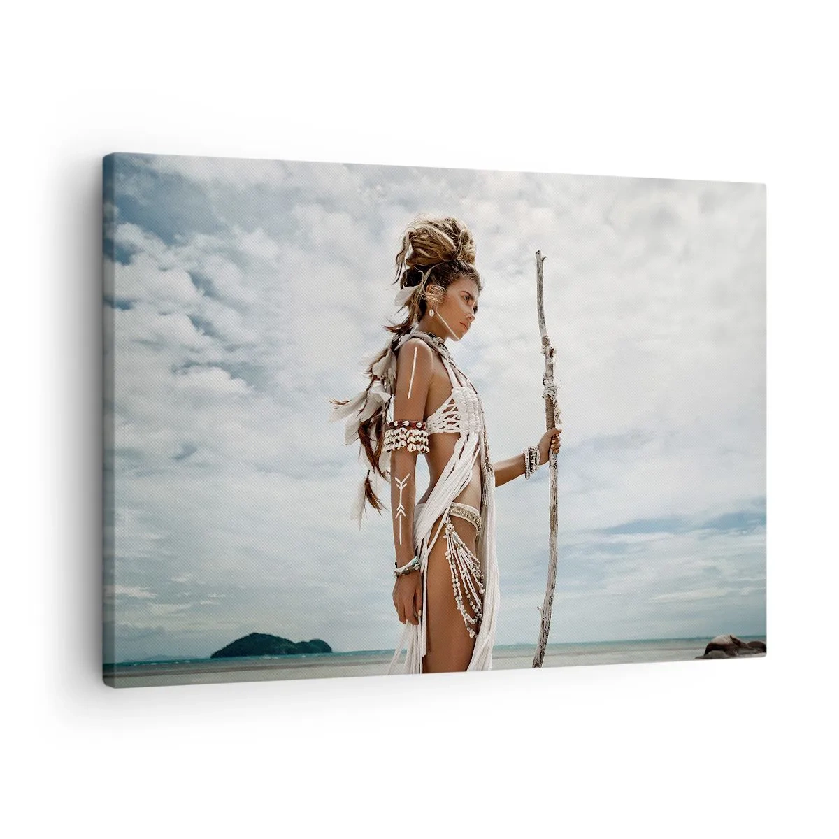 Obraz na płótnie - Stylizowana kobieta na plaży z etnicznymi ozdobami i kijem - 70x50cm - Królowa tropików - Nowoczesna dekoracja ścienna do salonu i sypialni ARTTOR