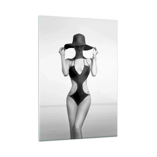 Obraz na szkle - Kobieta w czarnym stroju kąpielowym i kapeluszu na tle morza - 50x70cm - Na imię mi: Elegancja - Nowoczesna dekoracja ścienna do salonu, kuchni i sypialni ARTTOR