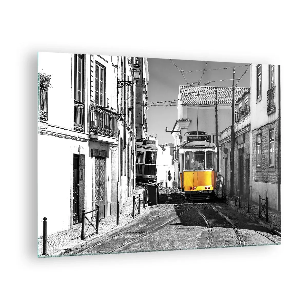 Obraz na szkle - Żółty tramwaj na czarno-białej ulicy europejskiego miasta - 70x50cm - Duch Lizbony - Nowoczesna dekoracja ścienna do salonu i sypialni ARTTOR
