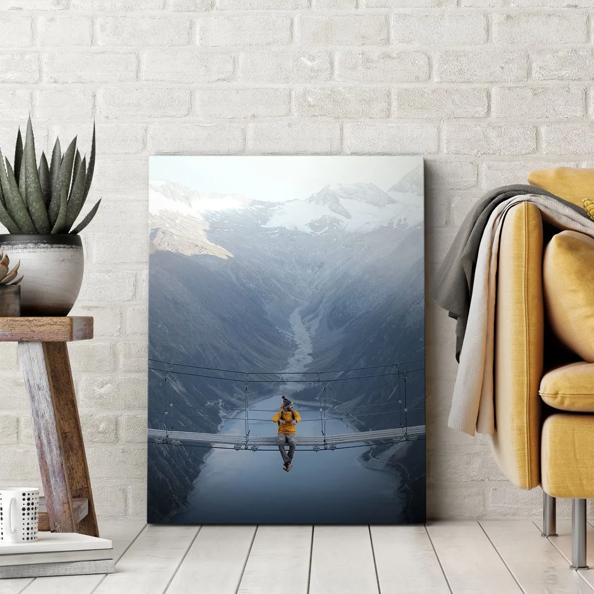 Obraz na płótnie - Osoba w żółtej kurtce siedząca na wiszącym moście nad górskim jeziorem - 80x120cm - Zachwycony w zawieszeniu - Nowoczesna dekoracja ścienna do salonu i sypialni ARTTOR