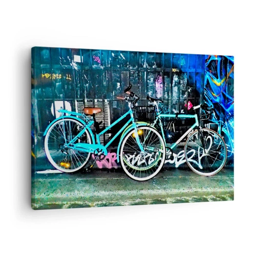Obraz na płótnie - Dwa turkusowe rowery na tle graffiti w miejskim stylu - 70x50cm - Miasto woła - Nowoczesna dekoracja ścienna do salonu i sypialni ARTTOR